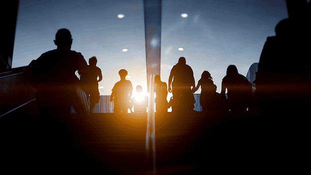 people walking up and down a staircase with a sunrise in the background